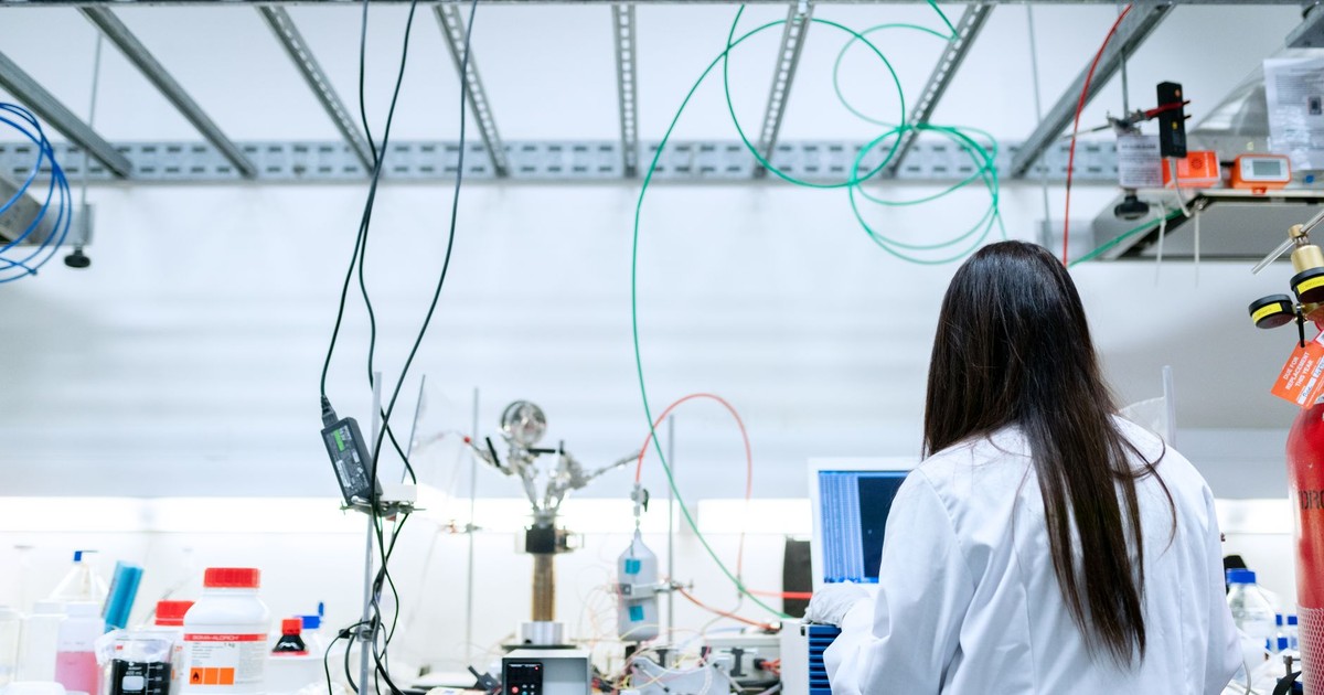 A female scientist conducting research in a contemporary laboratory full of equipment.