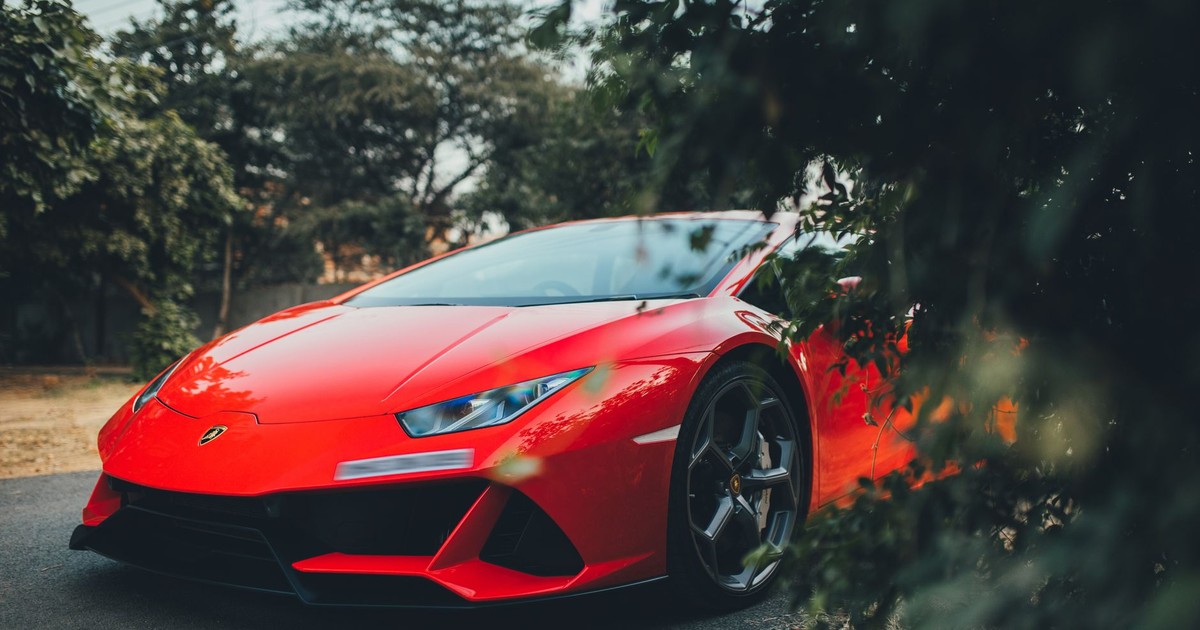 Vivid red Lamborghini Huracan parked outdoors in Gurugram, India, showcasing luxury automotive design.