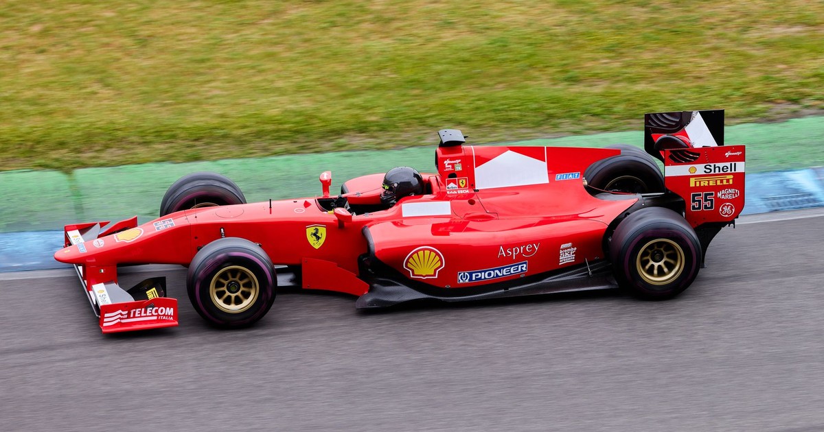 High-speed Formula 1 car in action on an outdoor racing track, showcasing motion and excitement.