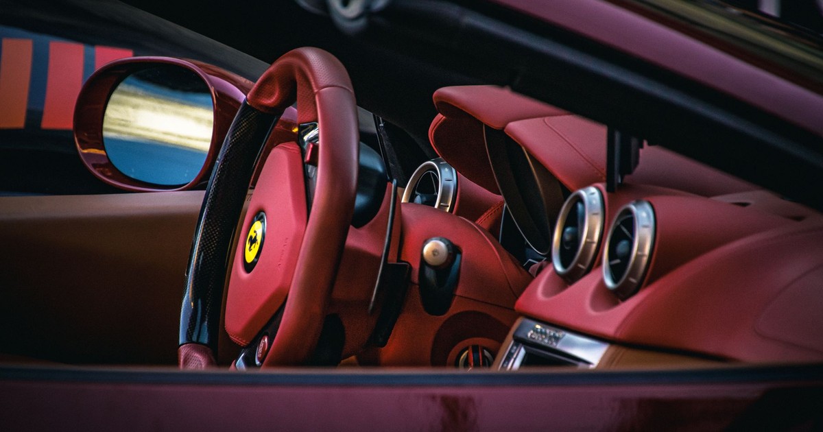 Close-up of a luxury sports car interior showcasing red leather seats and steering.