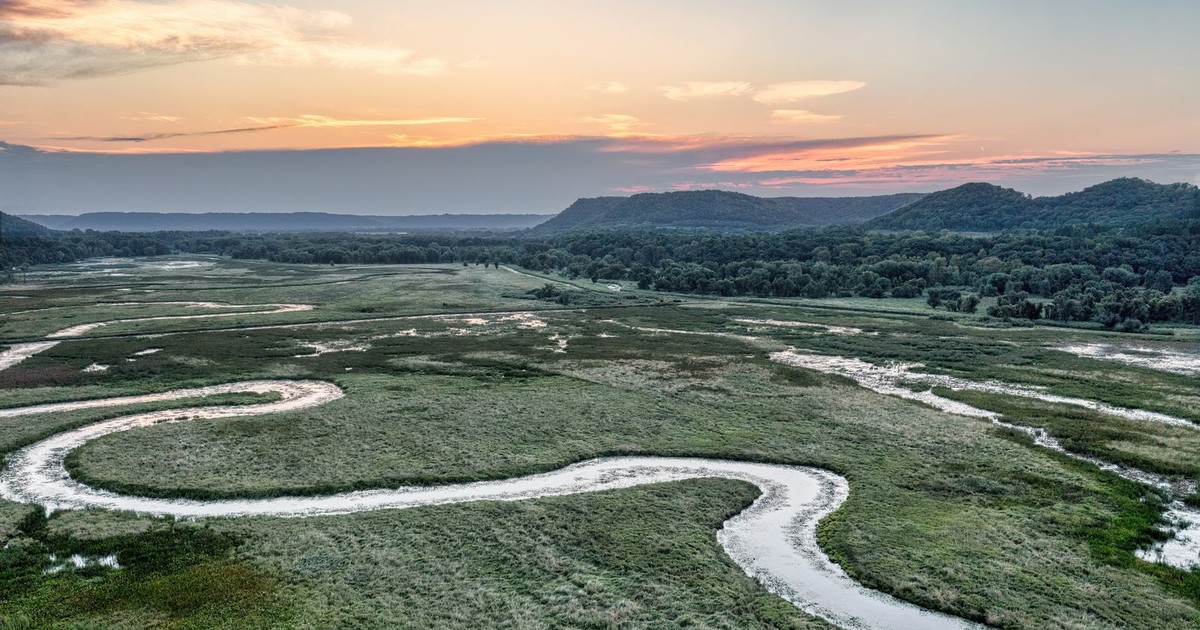 Aerial view of a meandering river through wetlands at sunset in Weaver, MN, USA.