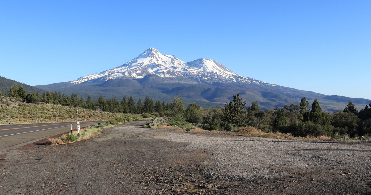 Majestic Mount Shasta with snowcapped peaks against a clear blue sky in northern California.