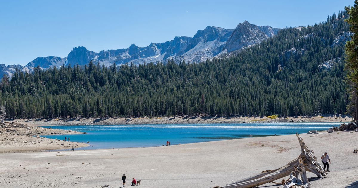 Beautiful mountain lake surrounded by forest and mountains on a sunny day.