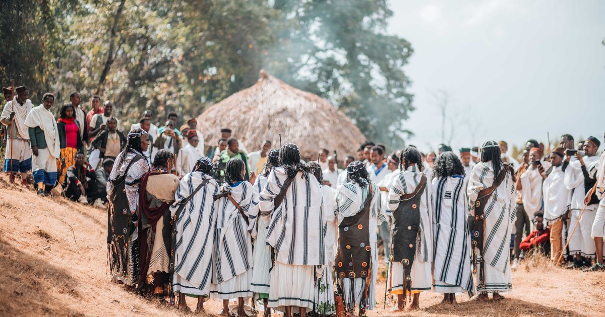A vibrant traditional ceremony with people in cultural attire outdoors.