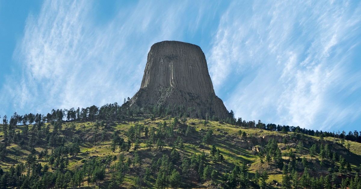 Stunning landscape of Devils Tower in Wyoming, showcasing its iconic rock formation against a clear blue sky.