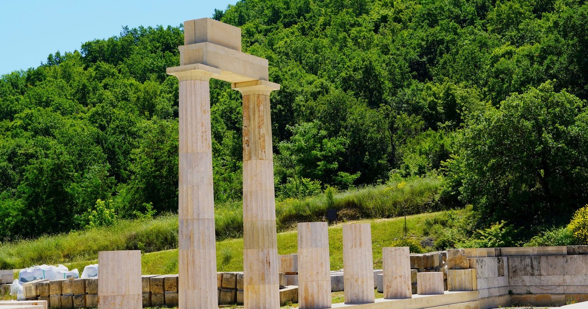 Classical stone columns set against a lush backdrop in Vergina, Greece.