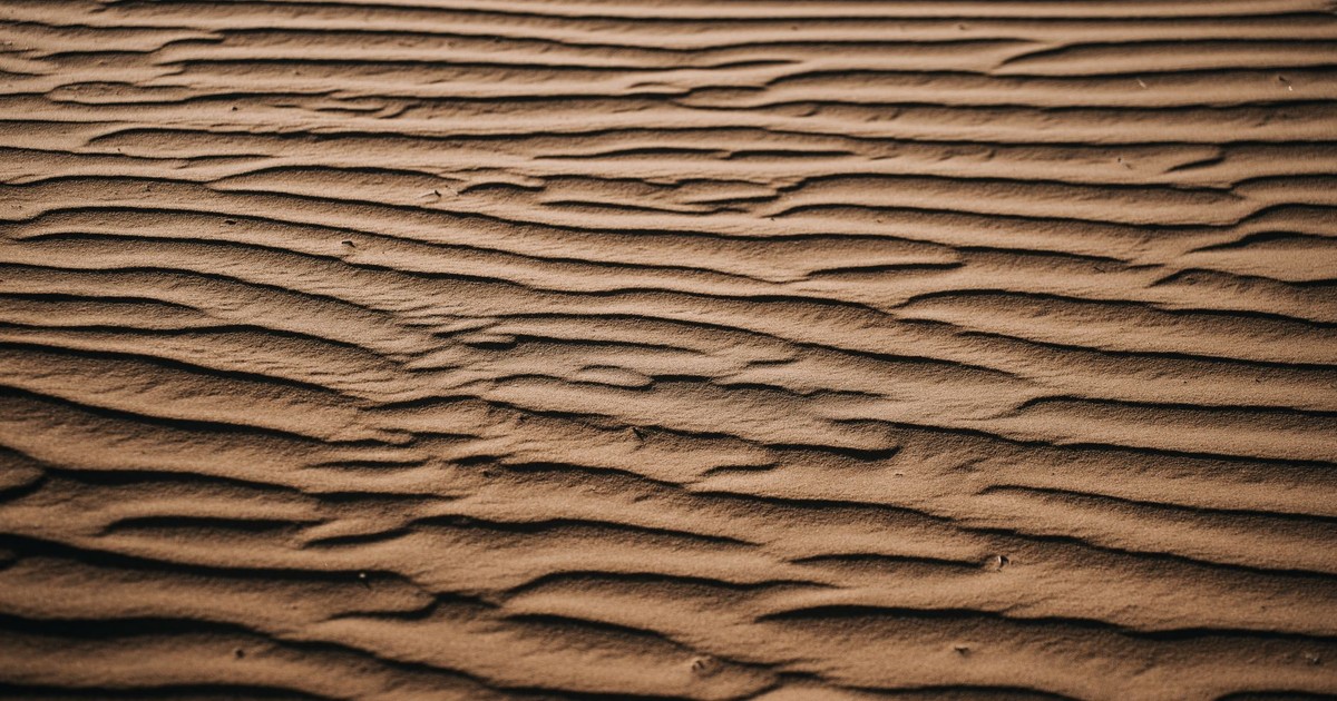 A detailed view of rippling sand patterns in a desert, showcasing natural textures.