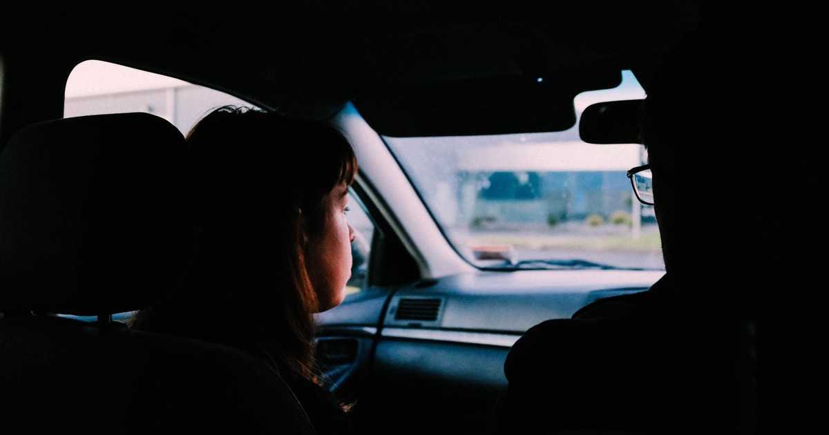 Two individuals captured inside a car, traveling during dusk, showcasing a serene driving experience.