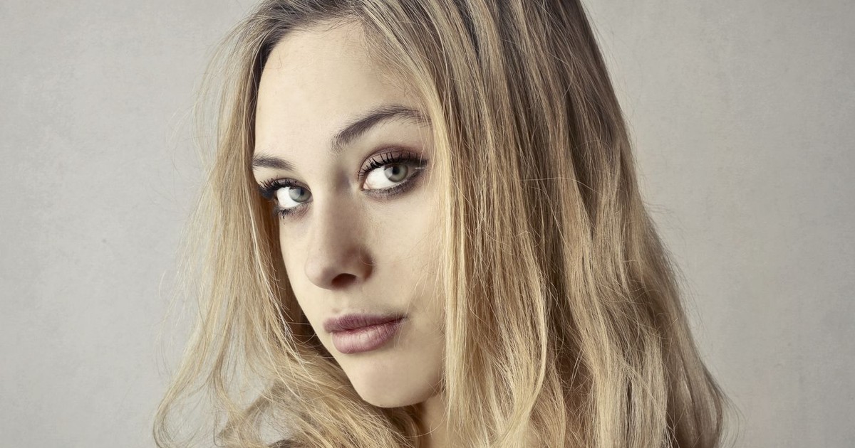Close-up portrait of a young woman with blonde hair and captivating eyes.