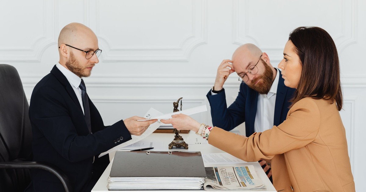 Professional meeting with lawyer and clients discussing documents in a modern office.