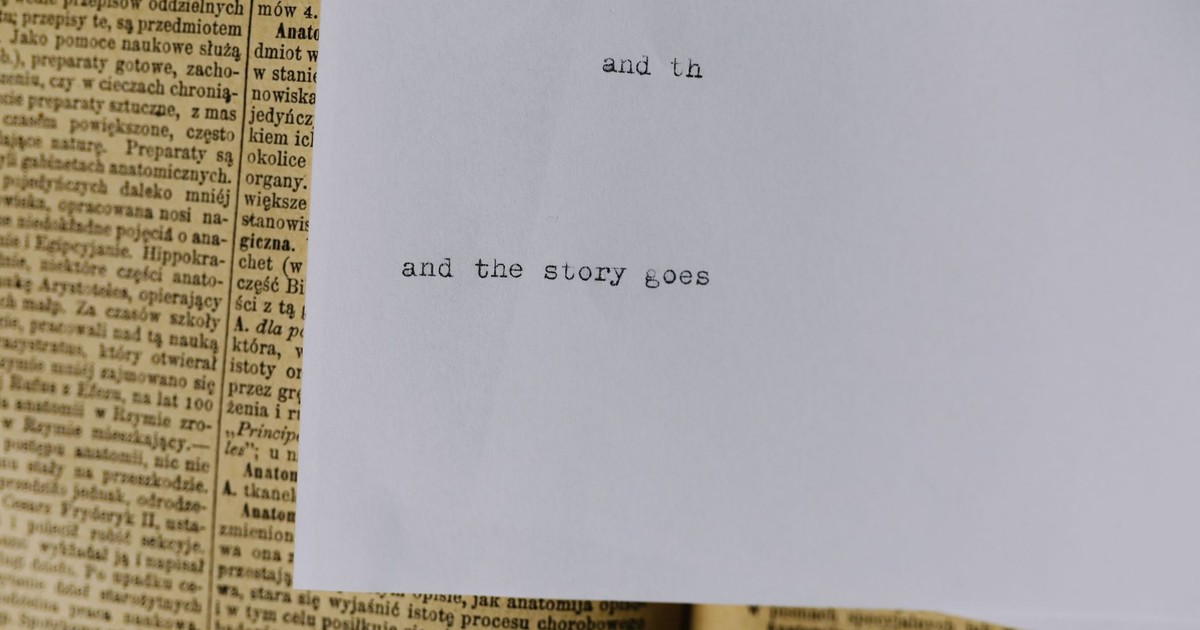 A piece of paper with typewritten text 'and the story goes' over an old book page.