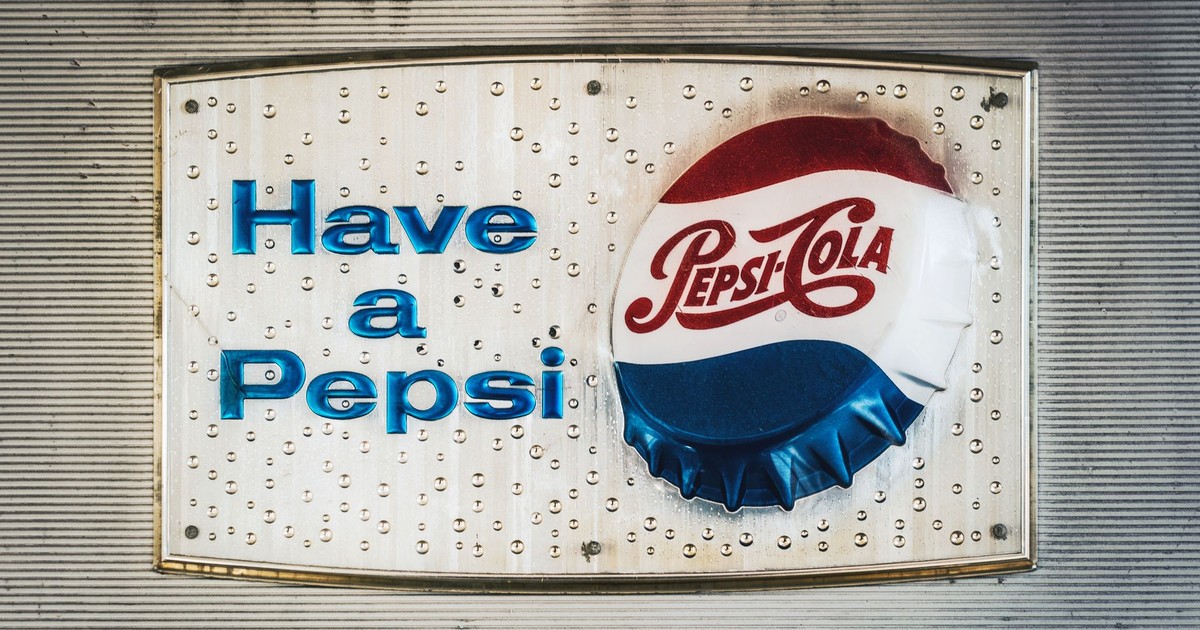 Retro Pepsi Cola sign featuring classic logo and bottle cap design.
