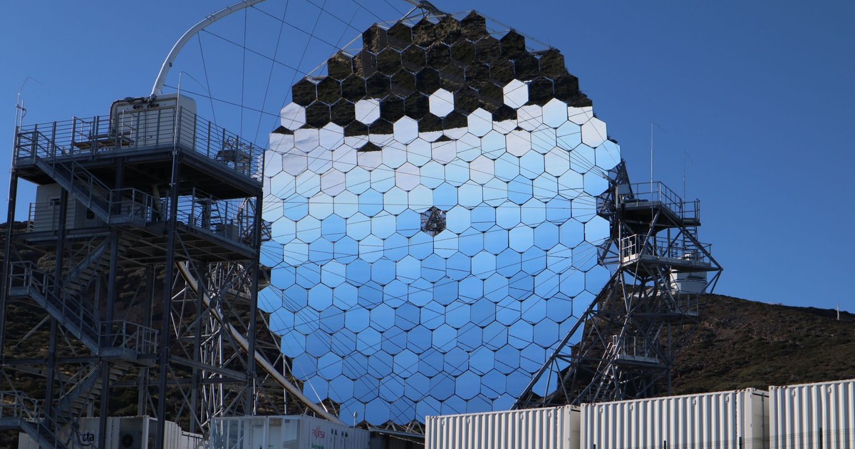 Futuristic reflective structure with hexagonal mirrors under a clear blue sky. Modern design.