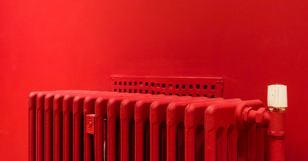 A vibrant red radiator against a matching wall captures minimalist and modern interior design.