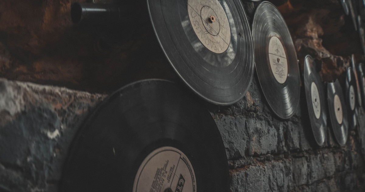 Close-up of vintage vinyl records displayed on a rustic brick wall, creating an artistic, nostalgic atmosphere.
