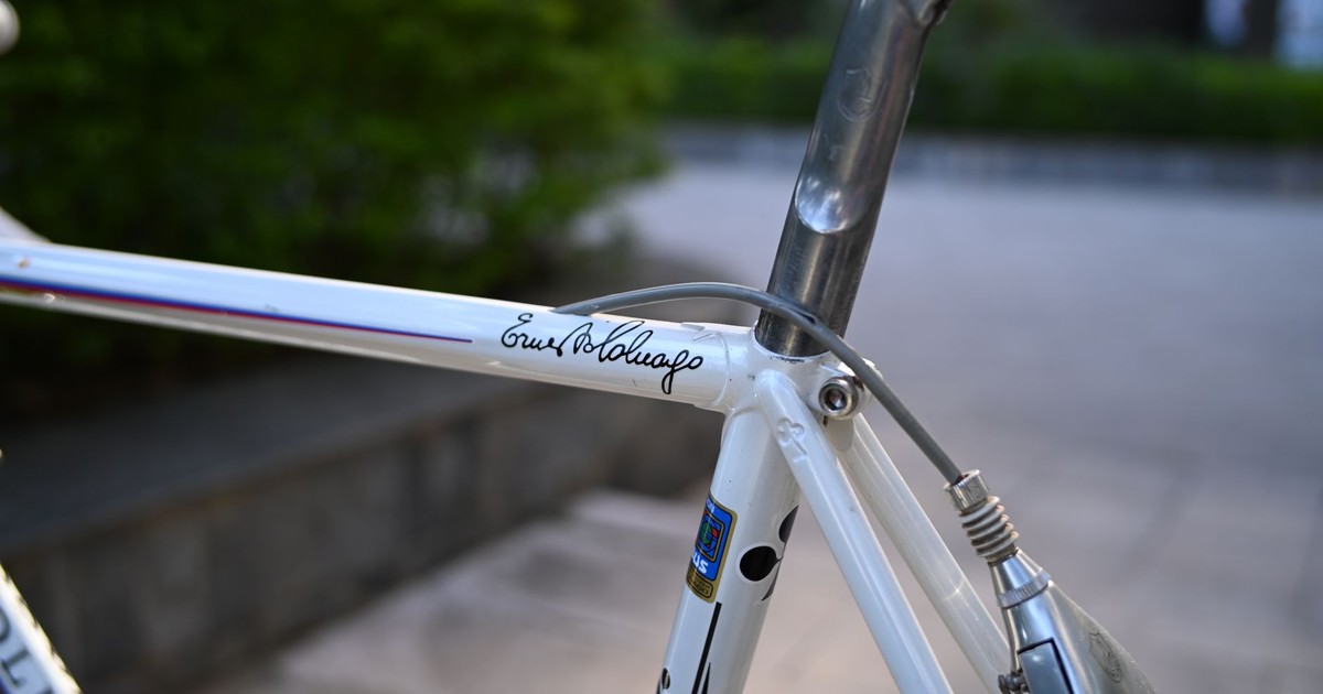 Detailed view of a vintage Colnago bicycle frame with signature, captured outdoors.