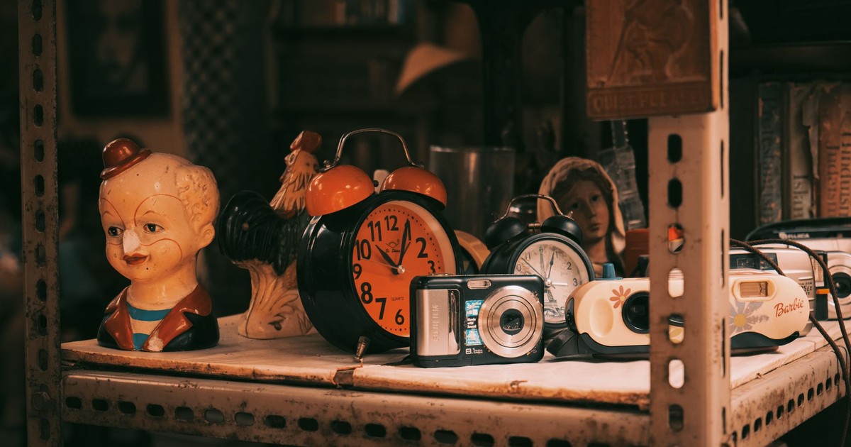 A rustic shelf displays vintage clocks, cameras, and quirky figures, evoking nostalgia and charm.