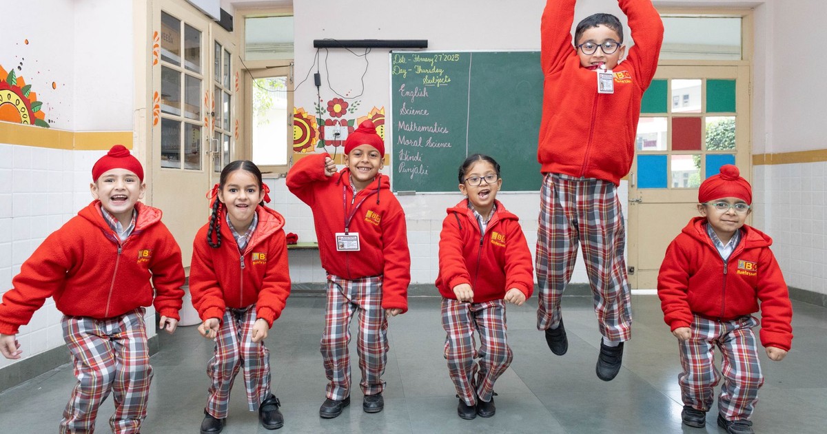 Group of cheerful school children jumping in a lively classroom setting, showcasing youthful energy.