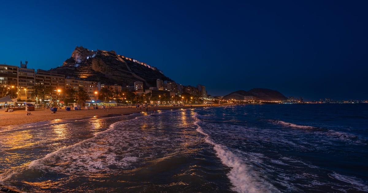 Beautiful view of Alicante's coastline with Santa Bárbara Castle illuminated at dusk.