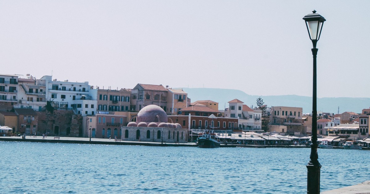 Beautiful waterfront view of Chania with historic architecture and blue sea.