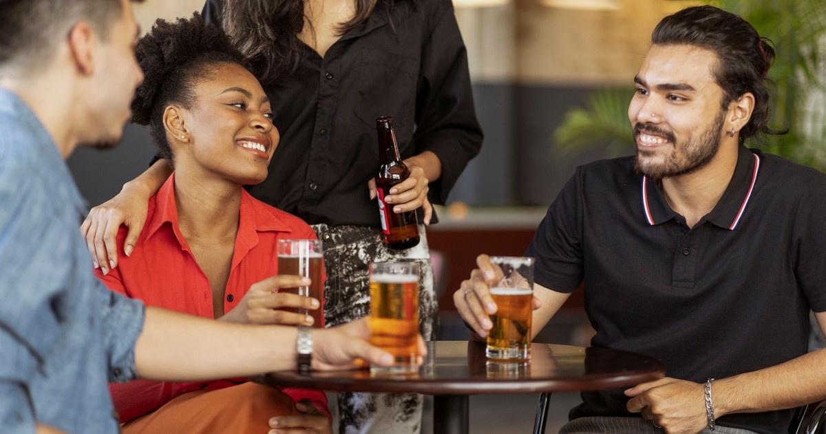Friends enjoying drinks and socializing at a cozy bar setting.