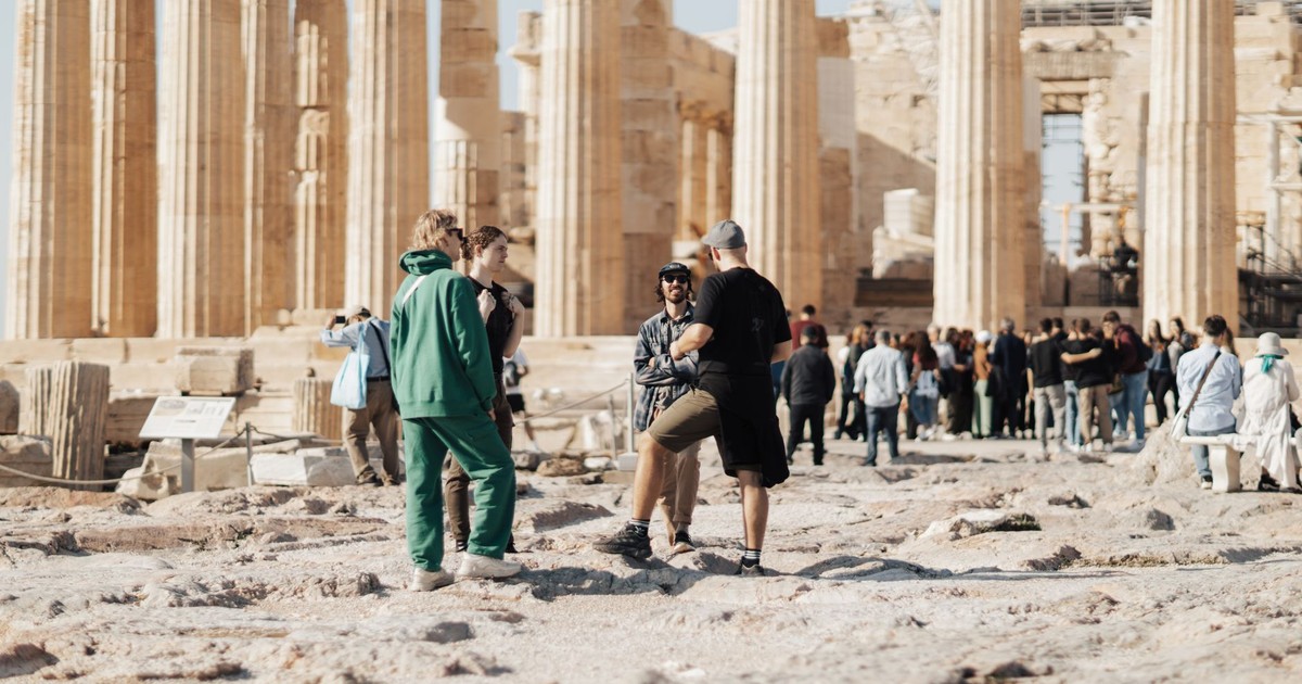 A group of tourists exploring the ancient ruins of the Parthenon in Athens, Greece.