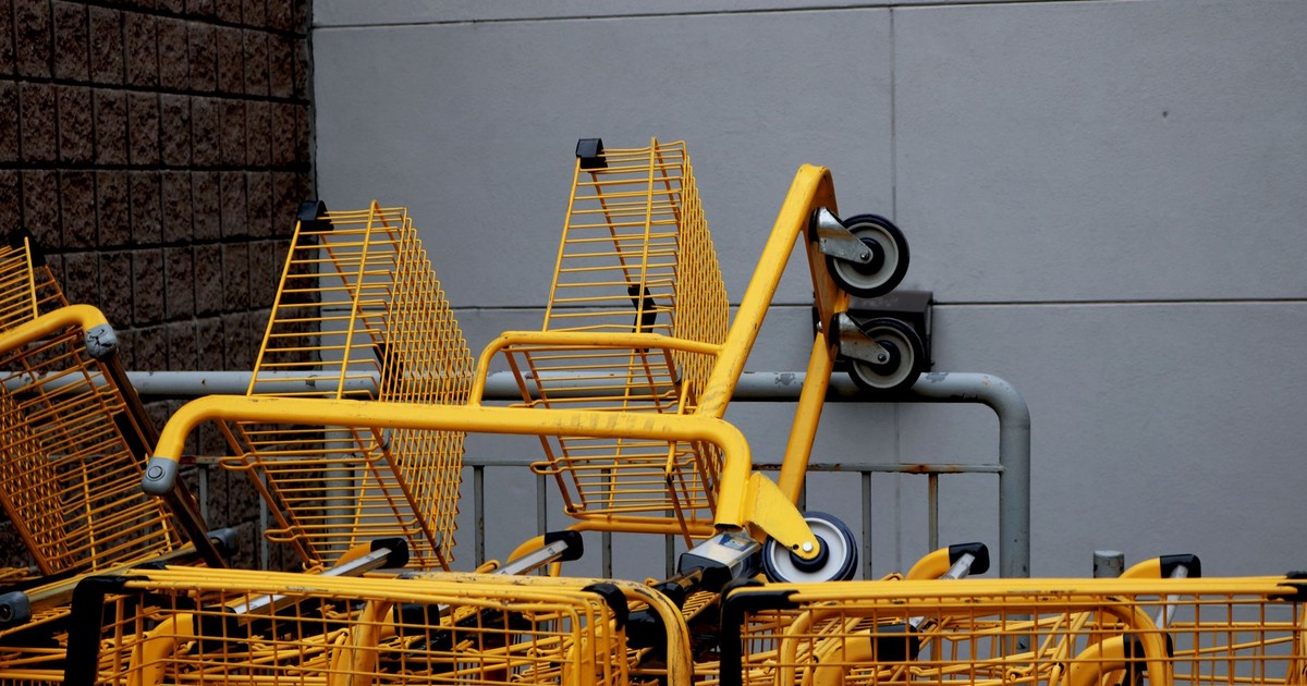 A stack of yellow shopping carts outside a building, showcasing industrial design.
