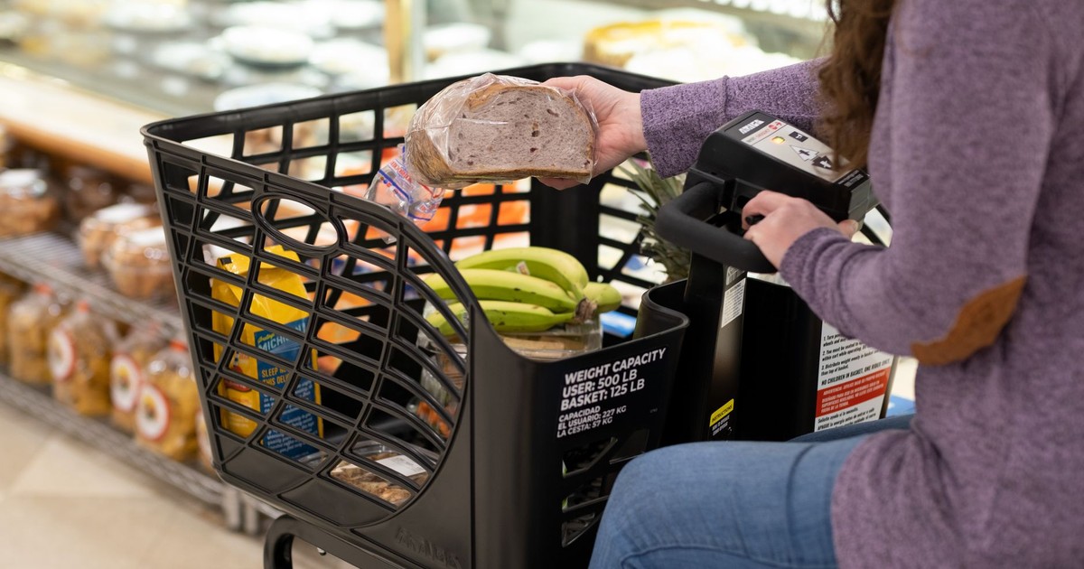 A shopper using a motorized cart selects groceries in a supermarket.