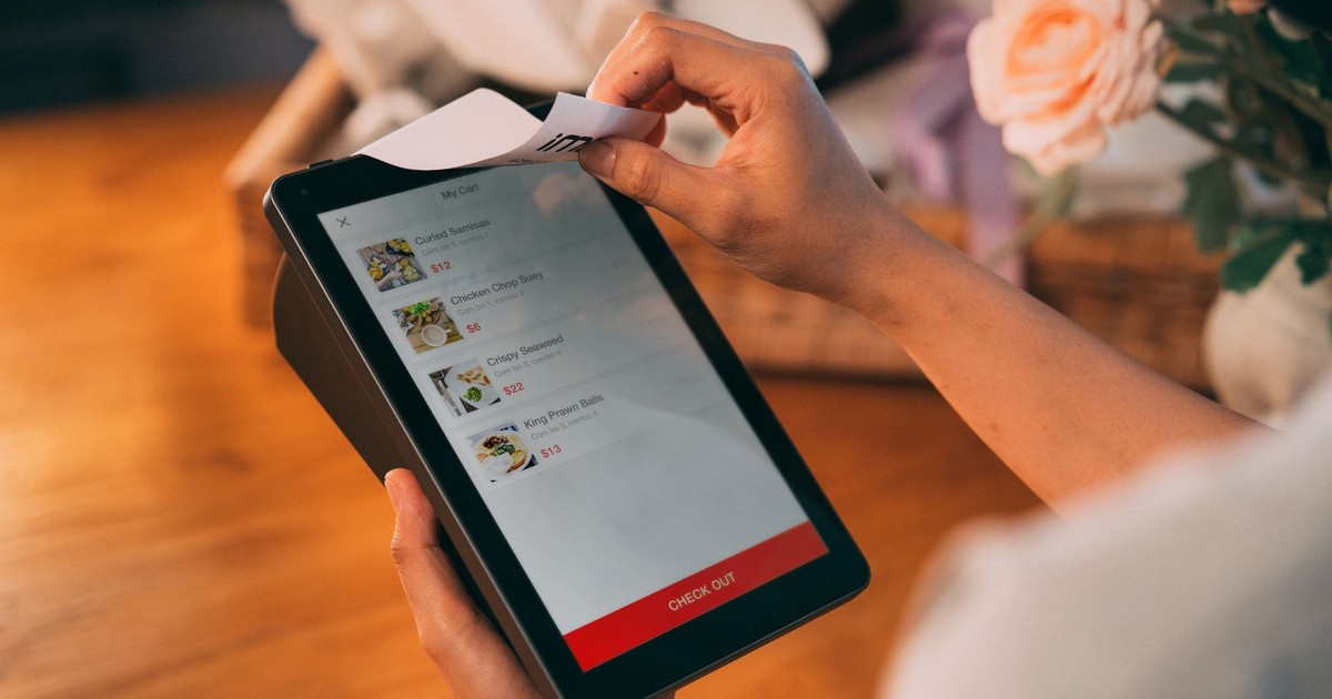 Hands using tablet for cashless payment, showcasing modern technology in retail.