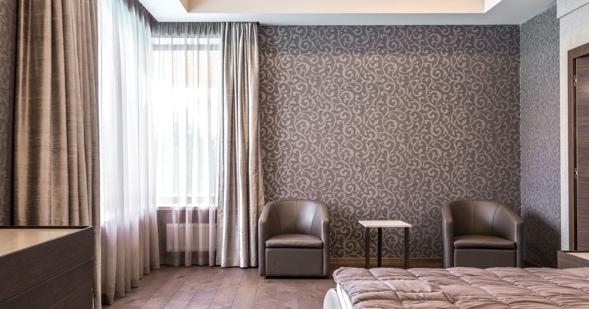 Spacious modern bedroom with stylish wallpaper and elegant furnishings.
