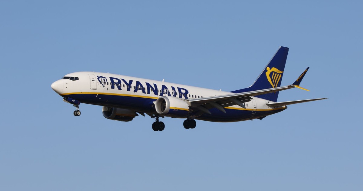 Ryanair airplane flying against a clear blue sky during daytime.