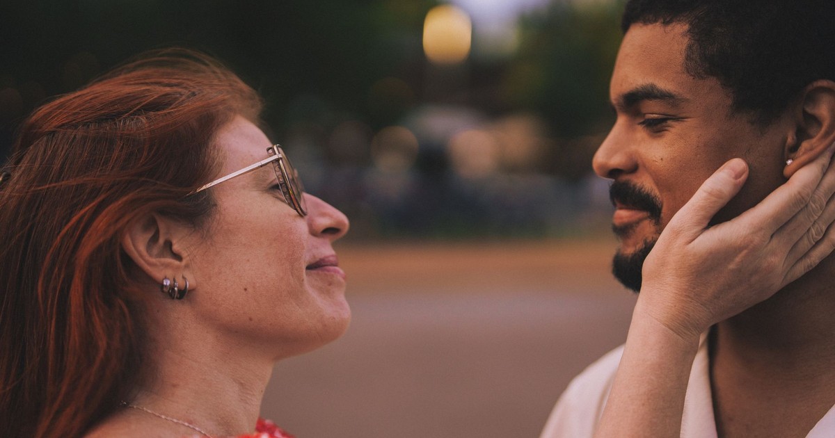 A couple shares a loving and intimate moment outdoors in a natural setting.