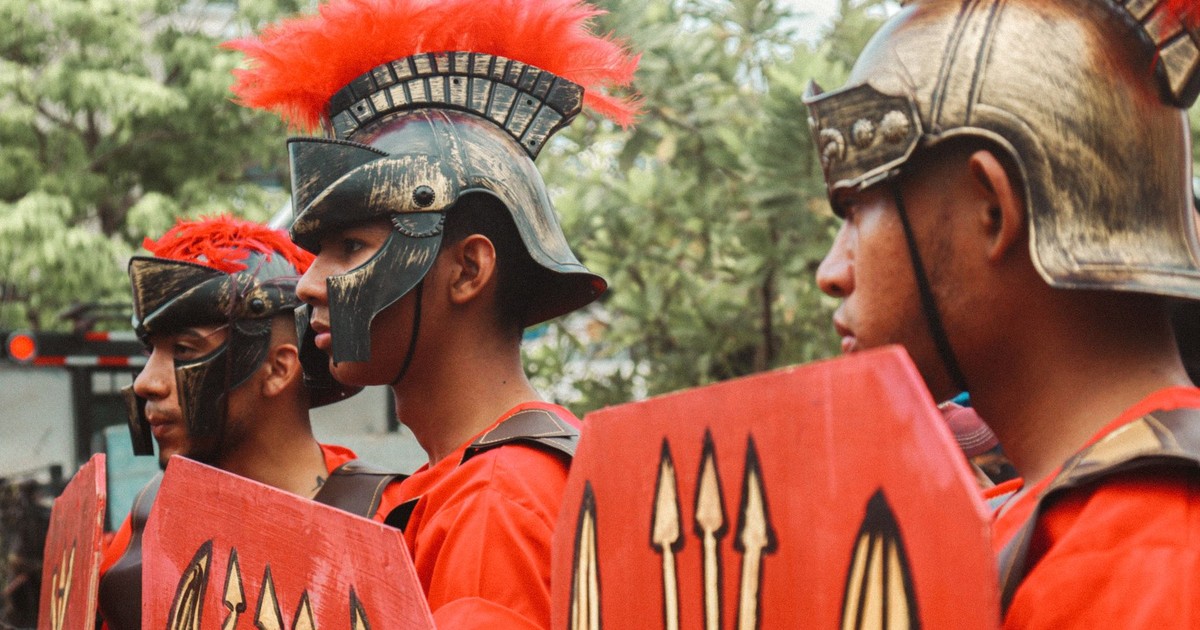 Men dressed as Roman warriors in a lively outdoor parade.