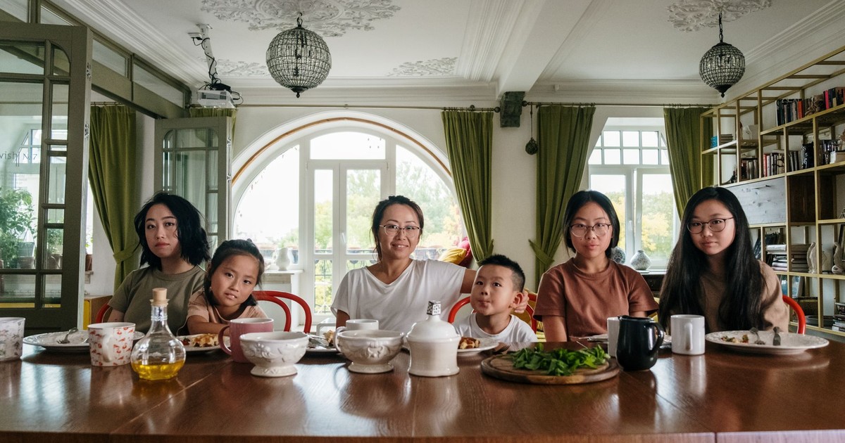 A diverse family enjoying dinner together in a cozy living room setting.