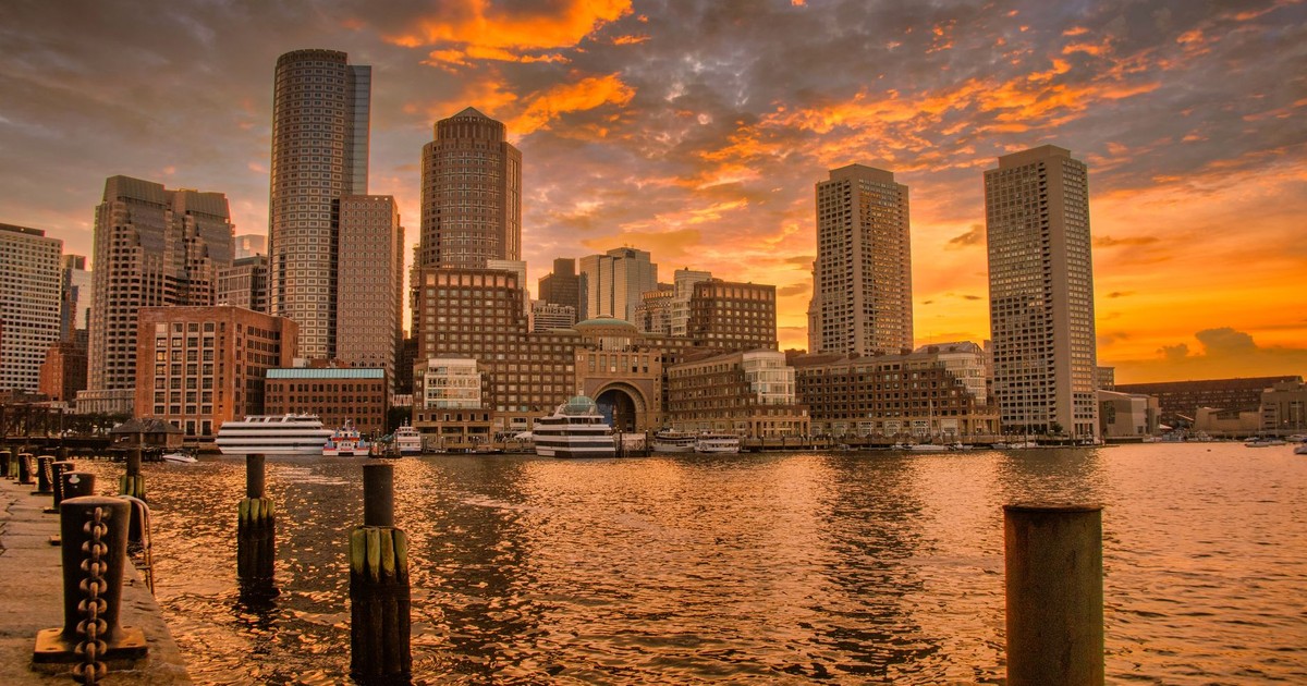 Stunning sunset over Boston's iconic skyline reflecting in the harbor waters.