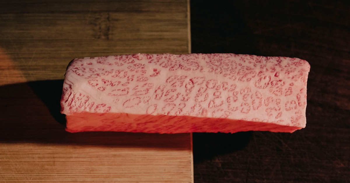 Close-up of premium marbled meat on a cutting board, showcasing texture and quality.