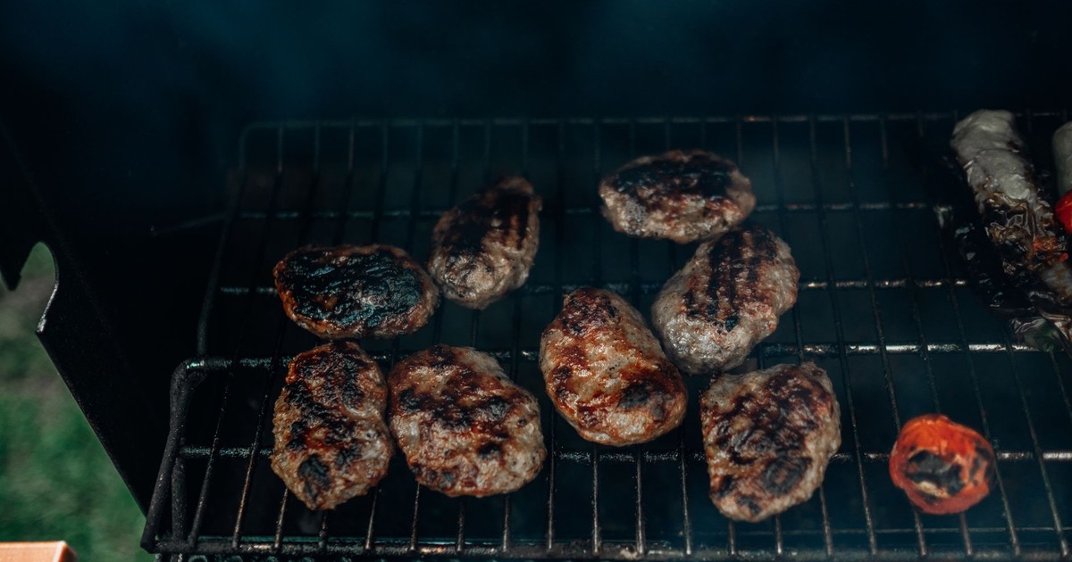 Succulent beef burgers grilling over charcoal for a delicious meal outdoors.