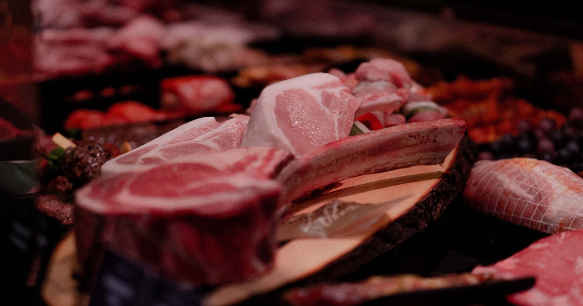Close-up of a variety of raw meats on display in a market setting, perfect for culinary and food industry themes.