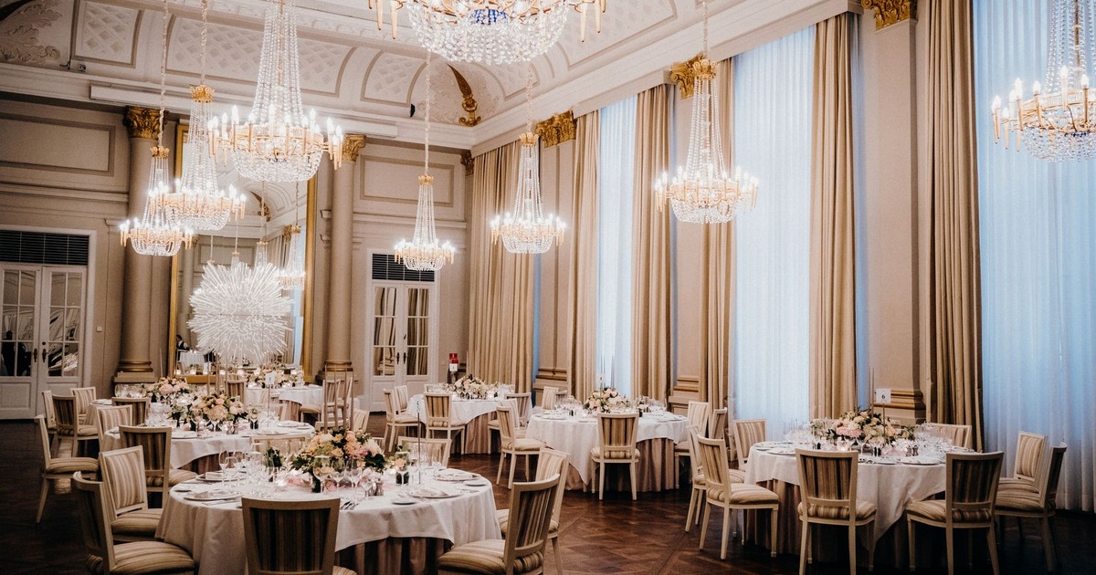 Luxurious ballroom featuring elegant chandeliers and a sophisticated dining arrangement, ideal for events.