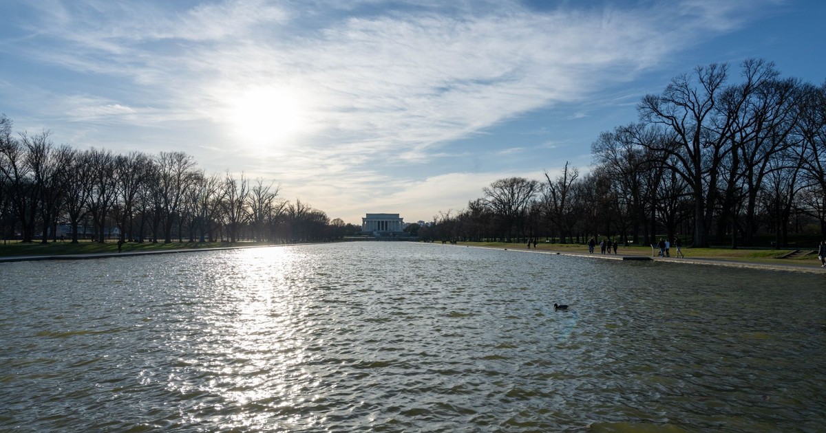 The Lincoln Memorial Reflecting Pool with serene water and clear sky in Washington DC.