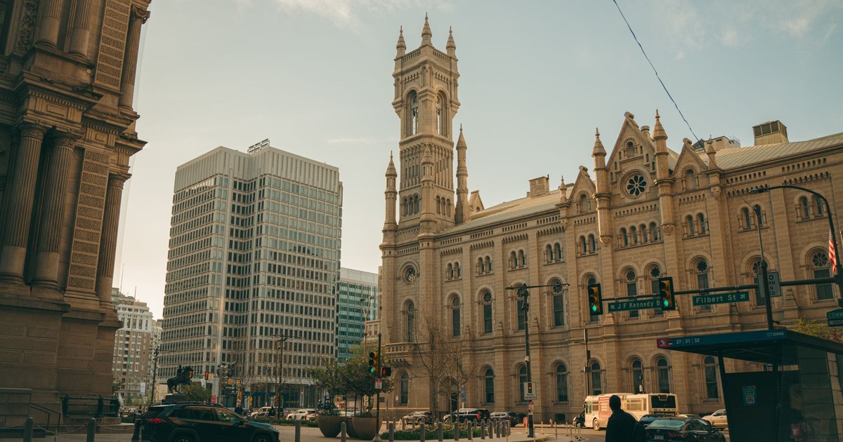 Street view of historic buildings and modern skyscrapers in Philadelphia, daylight setting.