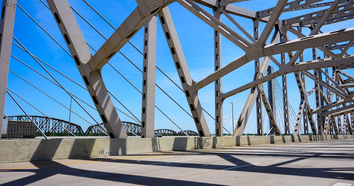 View of a steel bridge structure with shadows and blue sky in Louisville, Kentucky.