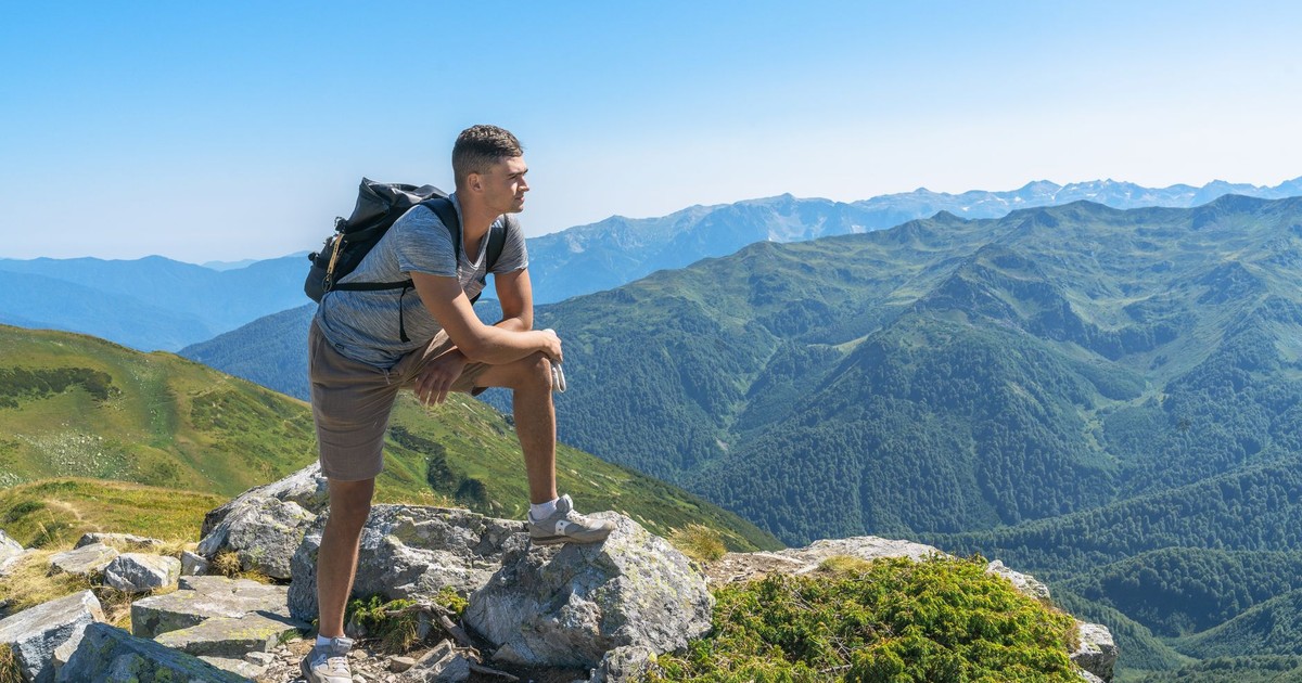 Man hiking in the picturesque mountains of Gagra, enjoying a sunny day.
