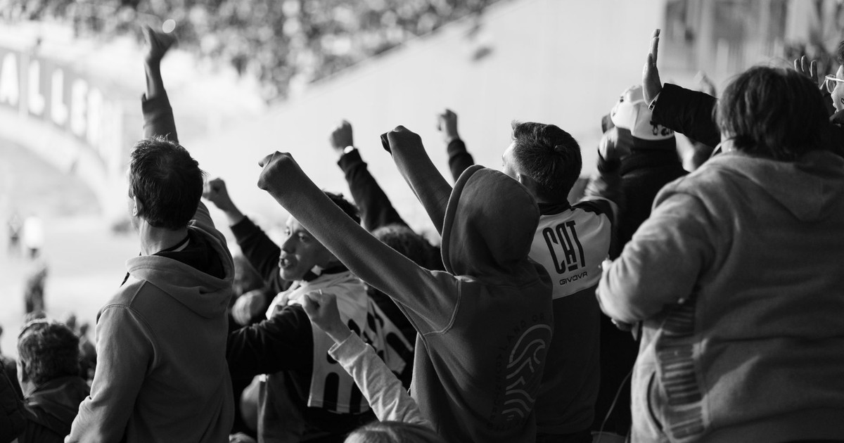 A crowd of enthusiastic football fans cheering inside a stadium in Córdoba, Argentina.