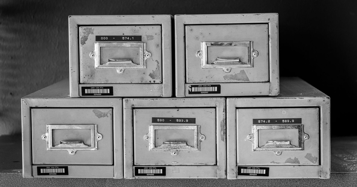 A set of five vintage metal file cabinets, aged and worn, displayed in black and white.