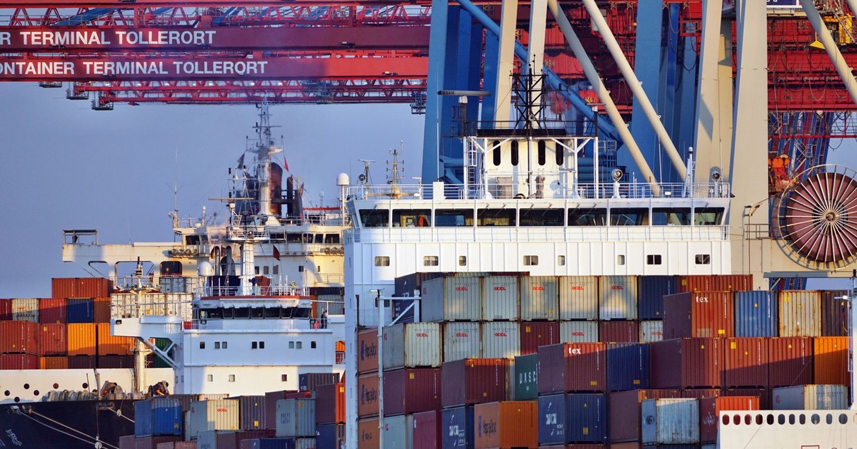 Container ships docked at Tollerort Terminal, Hamburg during sunset.