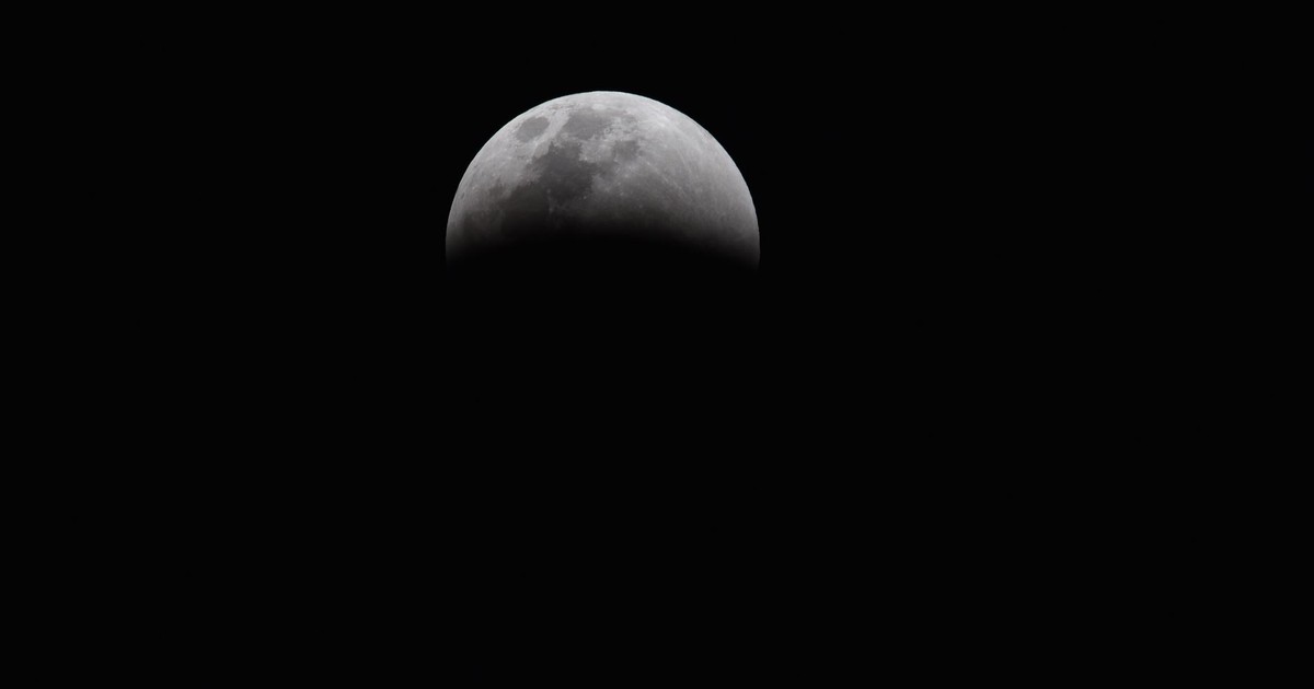 Dramatic view of a partial lunar eclipse showcasing the moon's shadowed surface against a dark sky.