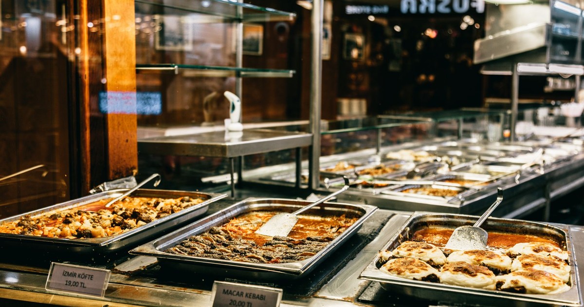 Different hot dishes in big bowls selling in self service restaurant at night