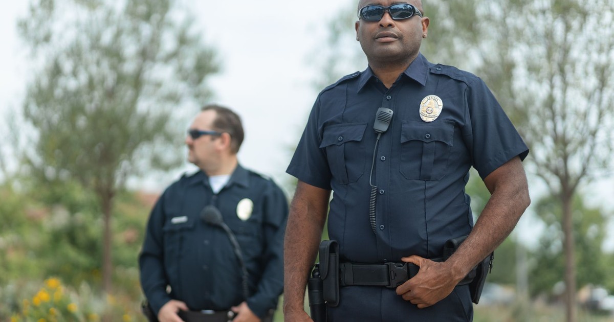 Two police officers in uniform ensure public safety, standing confidently outside.
