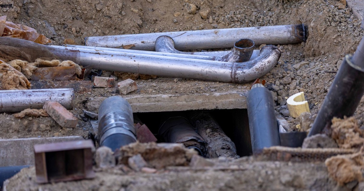 Close-up of urban pipe installation at a construction site, showing various pipes and materials.